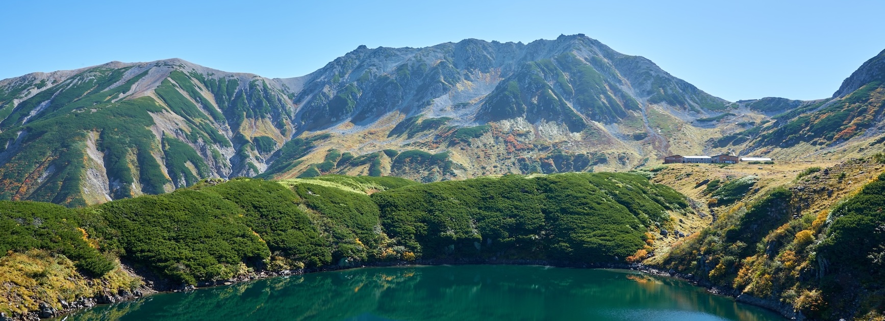 Serene morning reflection of the mountain range on a calm lake