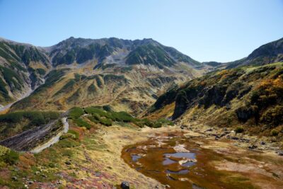 Against the backdrop of Mt. Tateyama's slopes, the marshland is dyed red and yellow by the autumn foliage of the grasses, spreading the colors of fall.