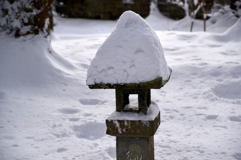 Stone lanterns in the grounds of Oyama Shrine, covered in deep snow