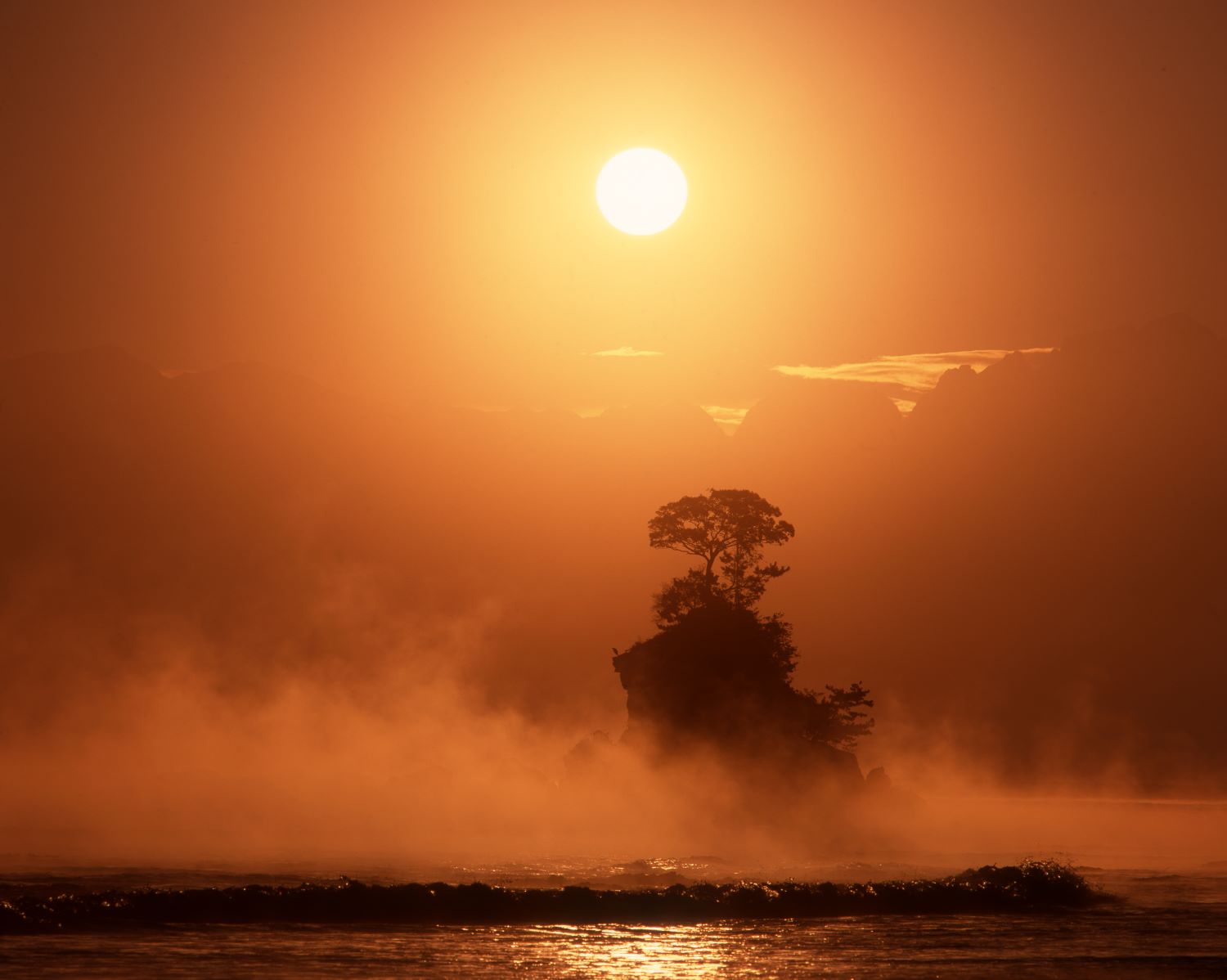 The sight of the Kiarashi and Onna-iwa silhouettes glowing in the morning sun along the Amahare Coast.