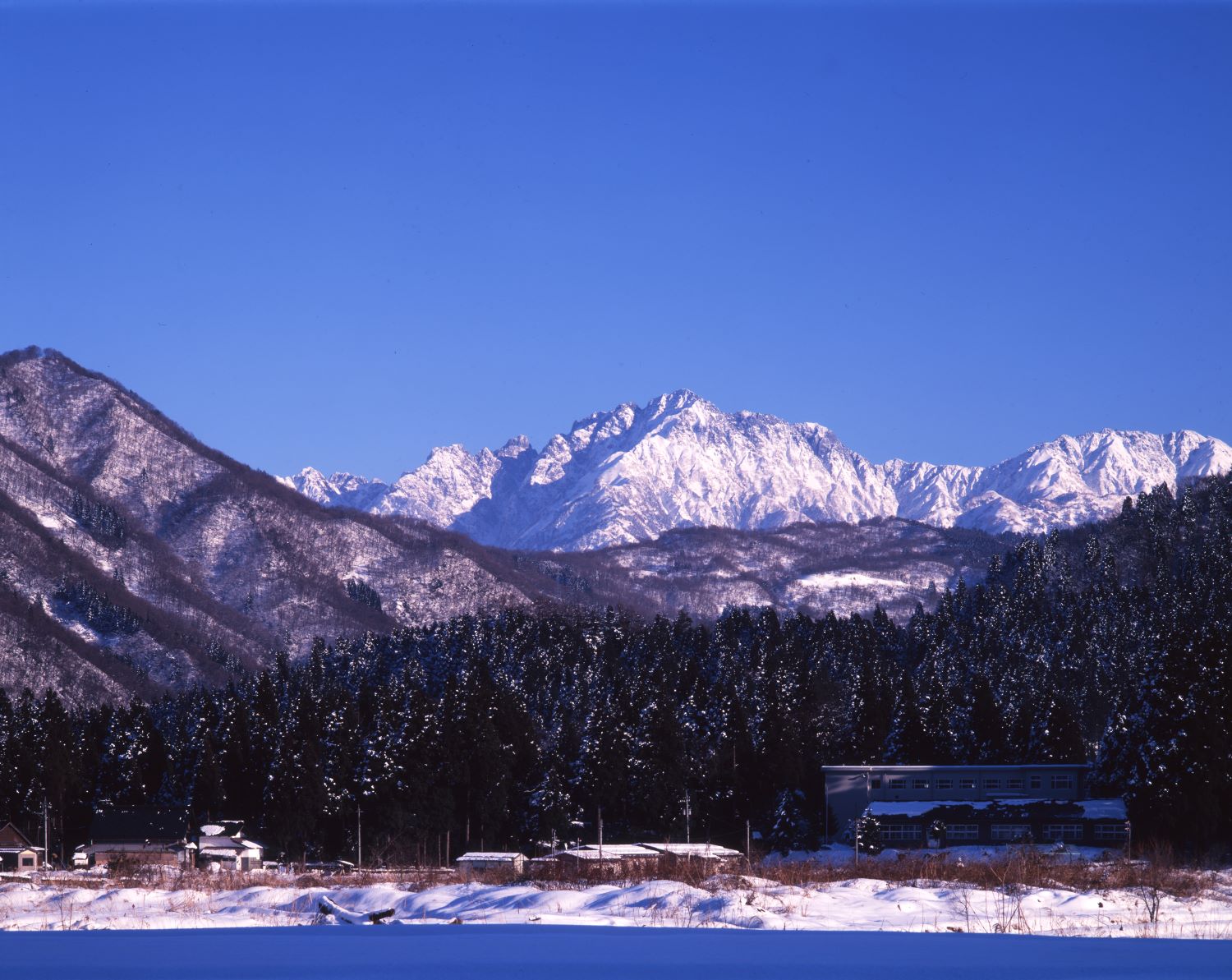 Deep within the winter satoyama and village, the snow-covered Mount Tsurugi stands out against the blue sky.