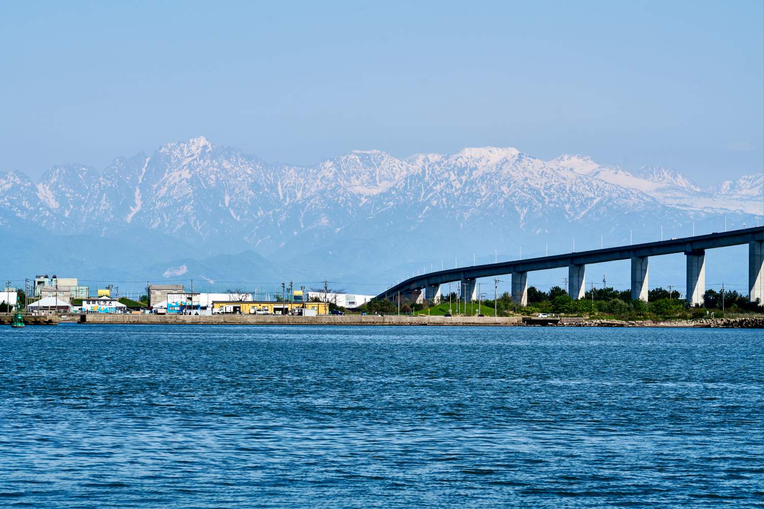 The view across Toyama Bay of the Shinminato Bridge and Mt. Tateyama.