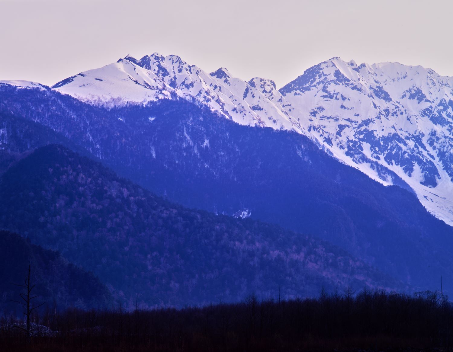 Late autumn view of the Nishihotaka Range from Kamikochi: snow-clad peaks and the setting sun's light