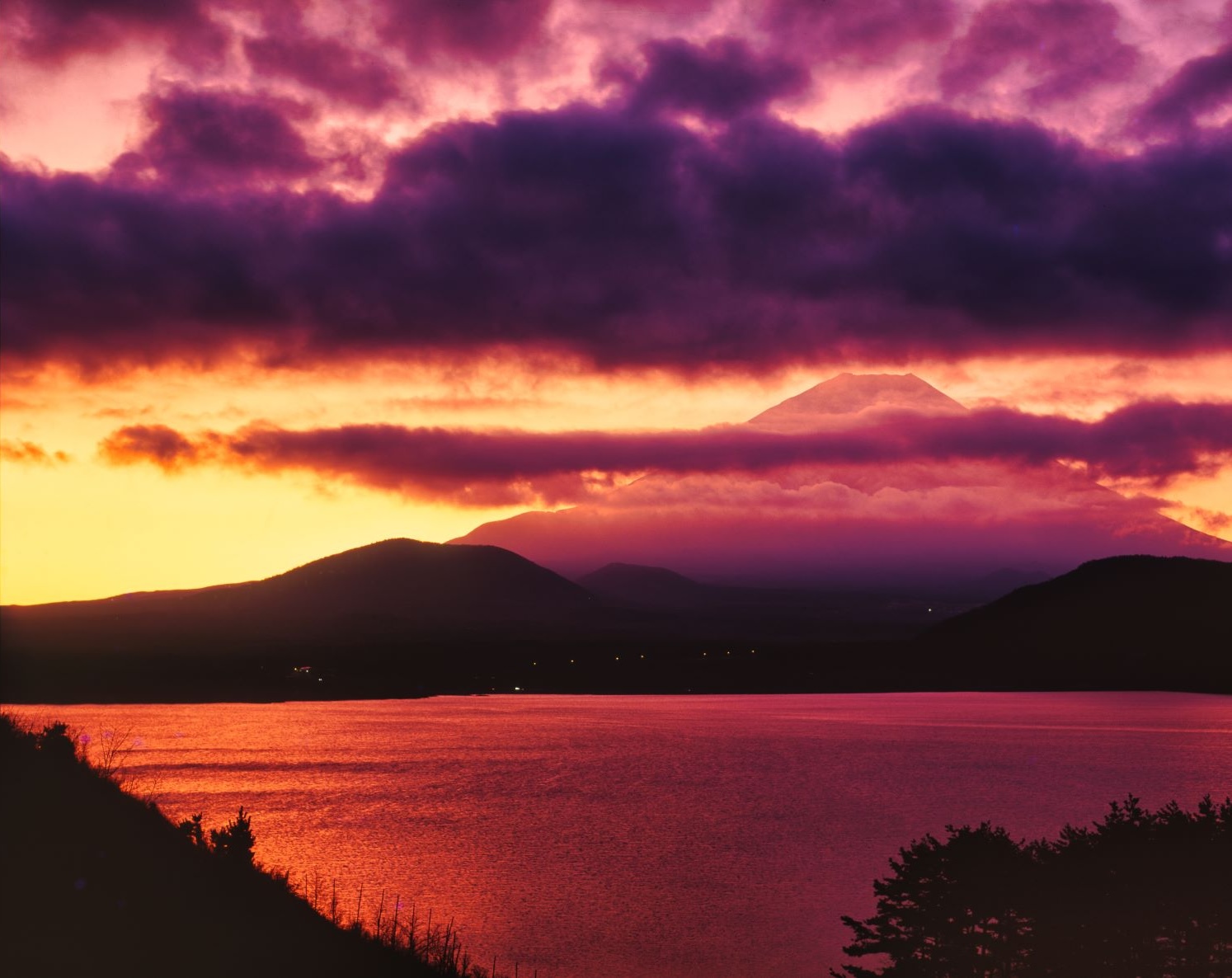 Lake Motosu dyed in the morning glow and the silhouette of Mount Fuji
