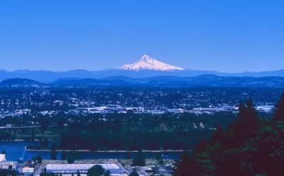 The cityscape of Portland and Mount Hood visible across the Willamette River