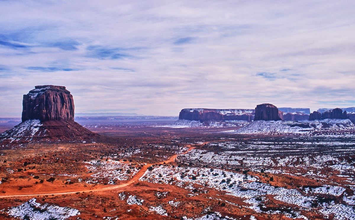 Snowy landscape of East Mitten Butte. Winter scenery of Monument Valley, where red earth and snow intertwine.