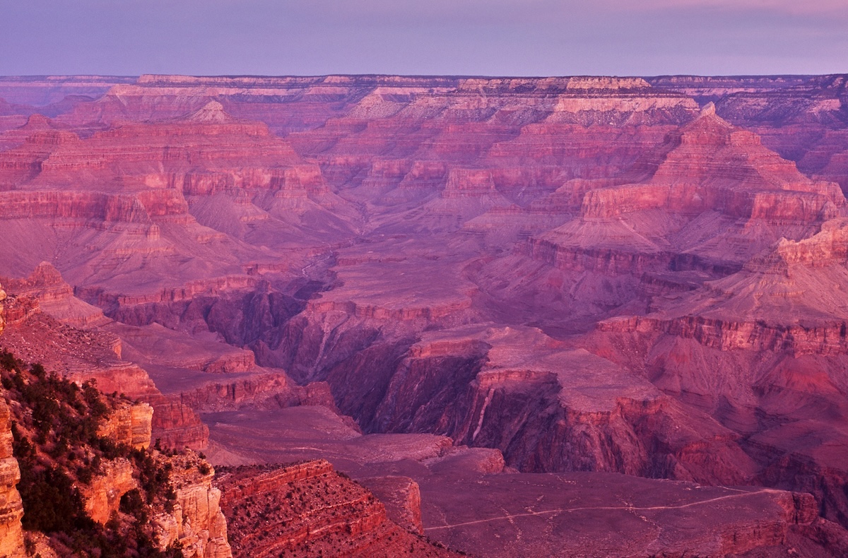 The Grand Canyon's layered rock face illuminated by the soft light of dusk