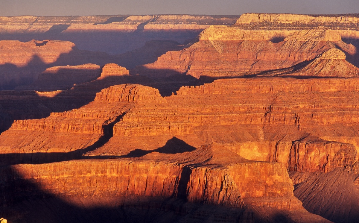 The Grand Canyon's cliffs glowing red in the sunset