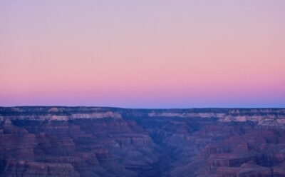 The panoramic view of the canyon bathed in purple and pink skies just after sunset at the Grand Canyon