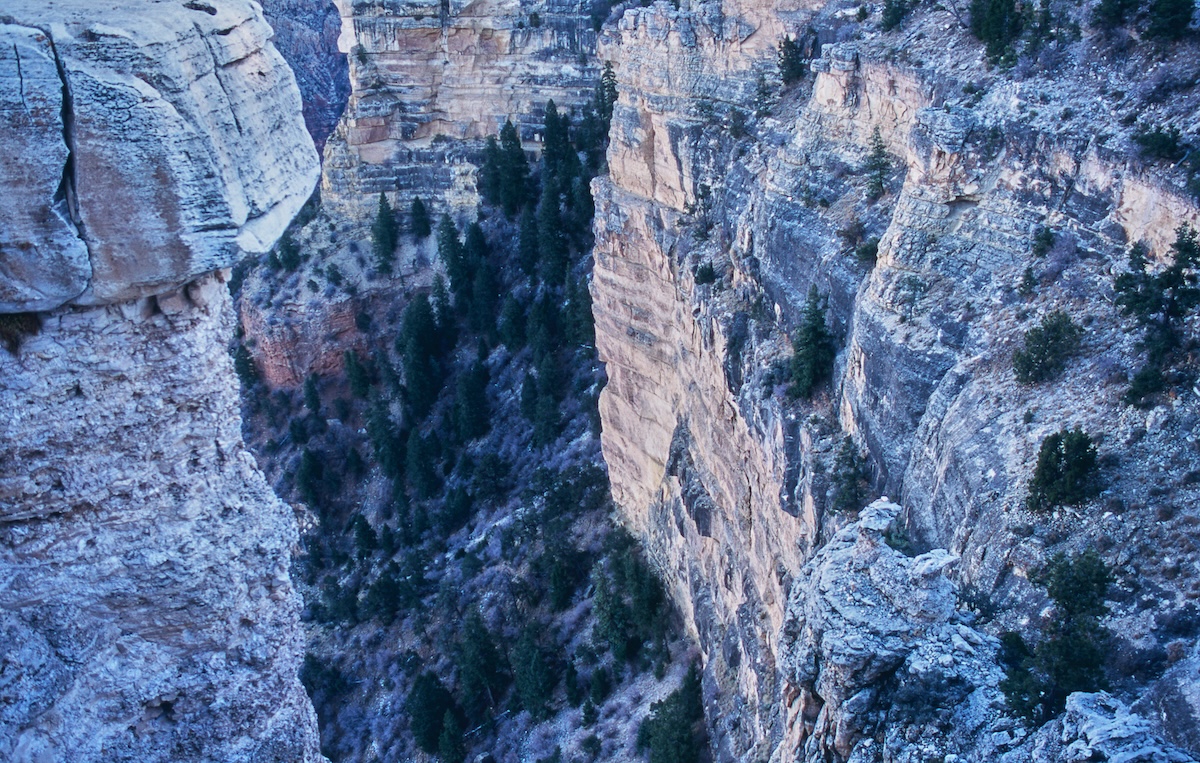 The exposed rock walls of the Grand Canyon, brightly illuminated by the midday sun