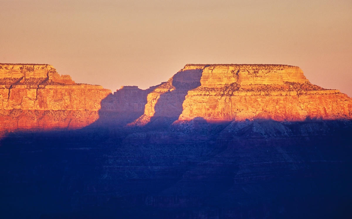 The Grand Canyon's highlands, bathed in orange by the setting sun